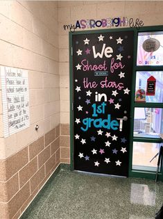 a classroom door decorated with stars and the words we shoot for the stars in 1st grade