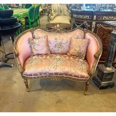 an antique couch with pink and gold upholstered fabric