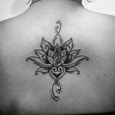 a woman's back with a lotus tattoo on it