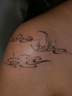 the back of a woman's shoulder with swirls and waves tattoo on it