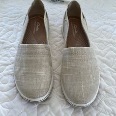 Women’s Causal Slip On Shoes By Clarks.Never Worn.Sz8m.Cute Shiny Natural Tan Fabric With Elastic Straps On Both Sides Of The Back Of Shoe.Cloudsteppers By Clark’s.Comfy And Soft Comfortable Cream Slip-on Flats, Casual Beige Flats With Ortholite Insole, Textile Low-top Slip-ons, Beige Low-top Slip-ons, Fabric Slip-ons With Round Toe, Beige Sneakers With Textured Footbed, Clarks Shoes Women, Work Flats, Tan Fabric