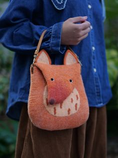 a woman holding a purse with a fox on it