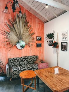 a living room filled with furniture and a wooden table in front of a wall mounted sunflower