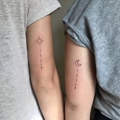 two people with matching tattoos on their arms, one is holding the other's arm