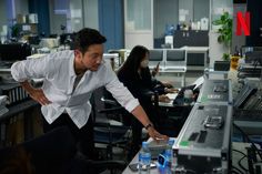 a man in an office setting leaning over a desk