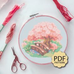 there is a cross stitch pattern with scissors next to it and some yarn on the table