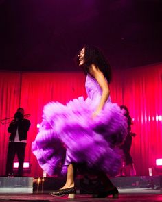 a woman in a purple dress on stage