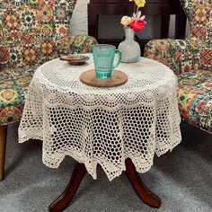 a table with two chairs and a vase filled with flowers sitting on top of it