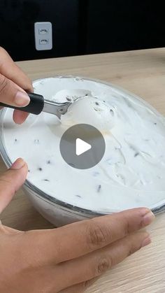 someone is using a spoon to dip something in a bowl with white liquid on it