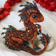 a beaded dragon sitting on top of a white surface