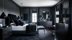 a bedroom with black walls and white bedding