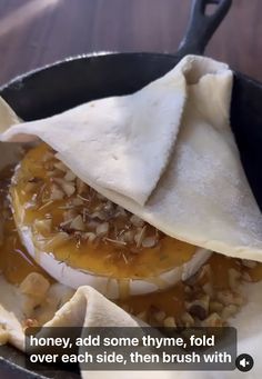 some kind of pita bread with toppings in a skillet on a table