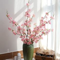 a vase filled with pink flowers on top of a table