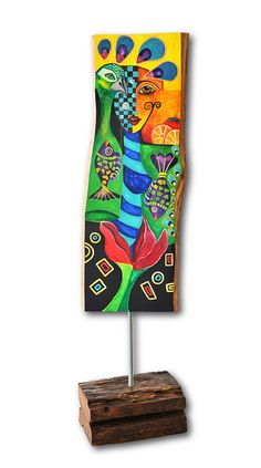 a colorful painting on a wooden stand next to a white wall