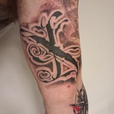 a man's arm with a cross tattoo on it and an arrow in the middle