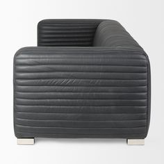 a black leather couch sitting on top of a white floor