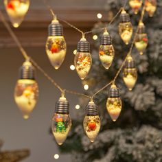 christmas lights hanging from a string in front of a tree