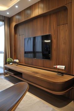 a modern living room with wood paneling and large screen tv on the entertainment center