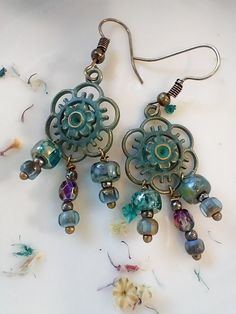 Fun & flirty boho earrings are so unique and cute! Hand wired assorted Czech glass beads dandle from green patina flower charms for a one of a kind pair! Nickel-free Bohemian Beaded Earrings For Crafting, Adjustable Bohemian Flower Earrings, Adjustable Bohemian Drop Flower Earrings, Bohemian Dangle Flower Earrings For Pierced Ears, Bohemian Czech Glass Dangle Flower Earrings, Handmade Czech Glass Flower Dangle Earrings, Nickel Free Czech Glass Flower Earrings, Artisan Czech Glass Beaded Earrings Nickel Free, Nickel-free Czech Glass Flower Dangle Earrings