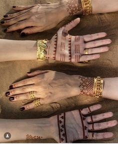 three hands with hendi designs on them and gold bracelets around their wristes