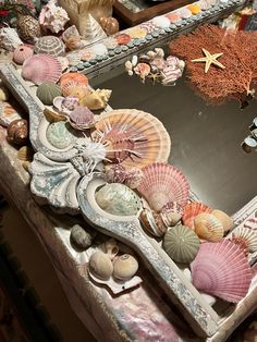 there are many seashells on the table and one is in an ornate frame