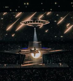 the stage is lit up with lights and an alien like object in the middle of it