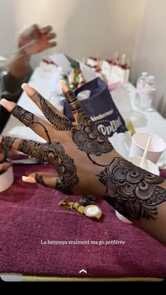 a woman's hand with henna tattoos on it