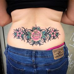 a woman's stomach with tattoos on it and flowers in the middle of her abdomen