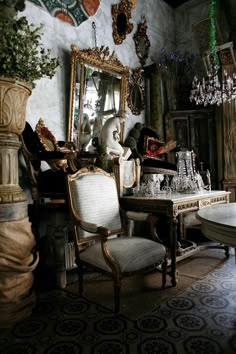 an ornately decorated dining room with chandelier and mirror on the wall above it