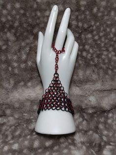 a white mannequin holding a red and black chain on it's hand