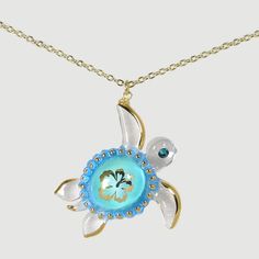 a necklace with a turtle on it's back and a flower in the center