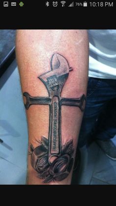 a man with a tattoo on his arm holding a wrench