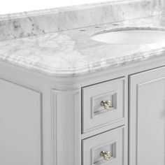 a bathroom vanity with marble top and drawers