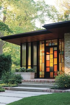 a modern house with stained glass windows and steps leading to the front door is shown