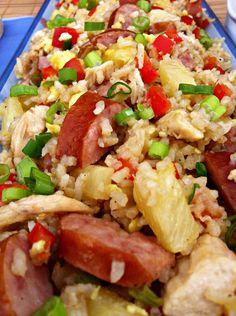 a blue plate topped with rice, sausage and veggies