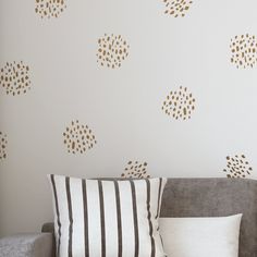 a living room with a couch and pillows on the floor next to a white wall