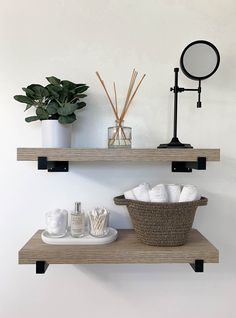 two shelves with towels, soaps and plants on them