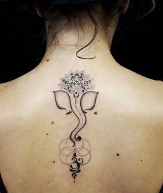 the back of a woman's neck with an elephant tattoo on it