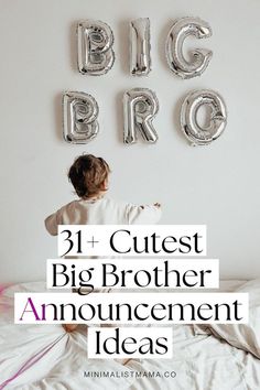 a little boy sitting on top of a bed next to balloons that spell out the word big bro