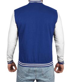 a man wearing a blue and white varsity jacket with the back turned to the camera