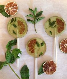 four popsicles with grapefruit, mint and orange slices arranged on top of each other