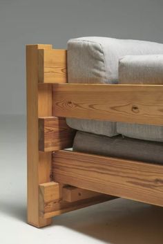 a wooden bunk bed with two pillows on it's bottom and the bottom half