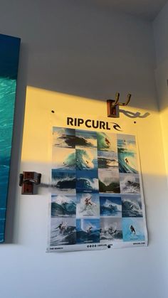 there is a surfboard hanging on the wall next to some pictures that are hung up