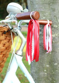 a bicycle with red and white ribbons attached to the handlebars