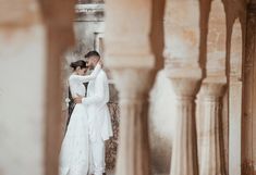 a bride and groom embracing in an archway