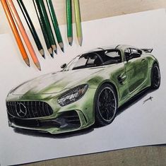 a drawing of a mercedes sports car with colored pencils on the table next to it