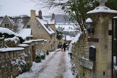 a snowy street lined with stone buildings and trees