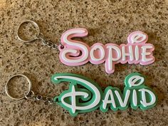 two key chains with the words sophie and david on them sitting on a counter