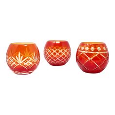 three red glass bowls with designs on them, one in the shape of a pineapple