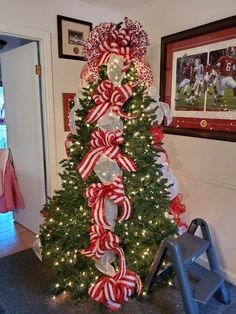 a christmas tree decorated with red and white bows